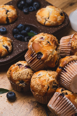 Blueberry muffins on a rustic table in a moldの写真素材