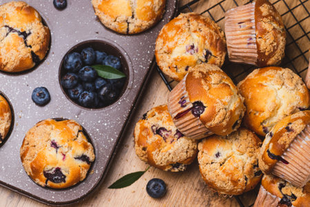 Blueberry muffins on a rustic table in a moldの写真素材