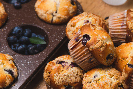Blueberry muffins on a rustic table in a moldの写真素材