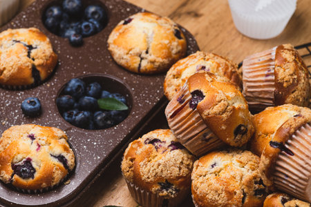 Blueberry muffins on a rustic table in a moldの写真素材