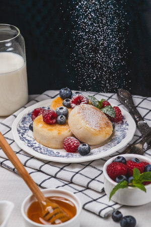 Cheesecakes with powdered sugar and berries on a plateの写真素材