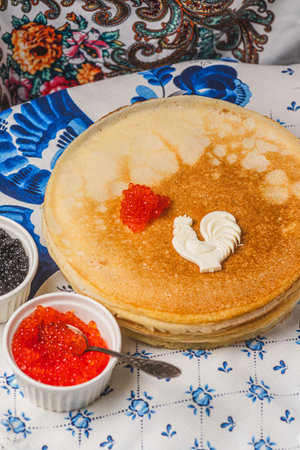 Pancakes on the table next to the samovar and caviar