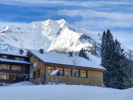 houses between snowy mountains in winterの写真素材