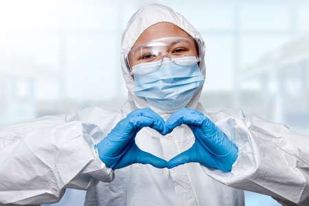 NHS medical technician holding make-up, doctor loving the work he does, mask, virus protection suitの写真素材