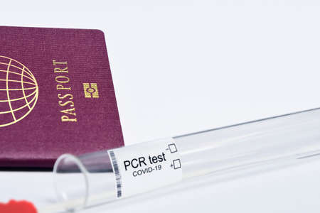 COVID-19 and travel concept, mark of coronavirus PCR testing in tourist passport. Diagnostics of coronavirus in airport due to lockdown. Business and tourism hit by corona virus during pandemicの写真素材