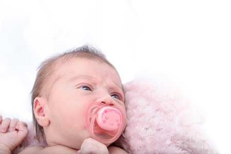 Beautiful Newborn baby girl sleeping, pink backgroundの写真素材
