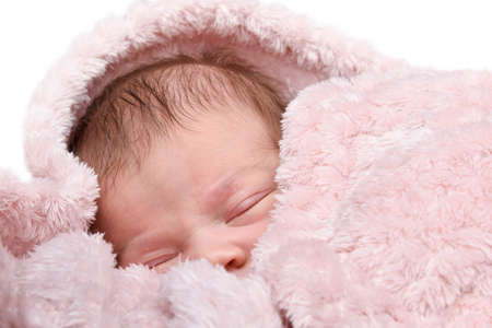 Beautiful Newborn baby girl sleeping, pink backgroundの写真素材