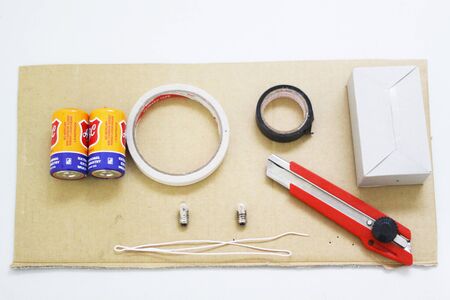 Two small bulb lamp, two lamp holder, cable, two large batteries, and a switch in a box and tableの写真素材