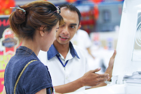 Store salesman assisting customer in electronic store at Bogor, West Java, Indonesiaの写真素材