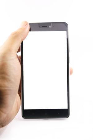 Hand holding mobile smart phone with blank screen. Isolated on whiteの写真素材