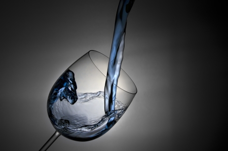 Pouring water into a glass splash の写真素材