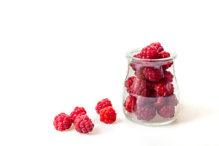 cup full of fresh garden raspberries on a white backgroundの写真素材