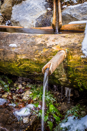 old water fountain in a wooden troughの写真素材