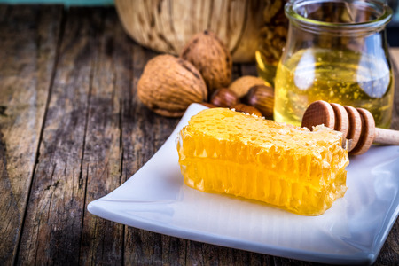 honey dipper and honeycomb, nuts in honey and nuts of various kinds,の写真素材