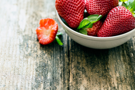 bowl of fresh strawberries on old wooden tableの写真素材