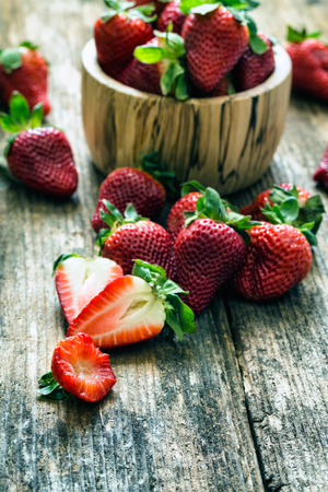 wooden bowl of fresh strawberries on old wooden tableの写真素材