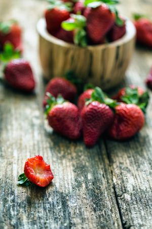 wooden bowl of fresh strawberries on old wooden tableの写真素材