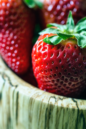 wooden bowl of fresh strawberries on old wooden tableの写真素材