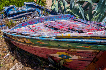Traditional old leaky boat on the Algarve coast of Portugalの写真素材