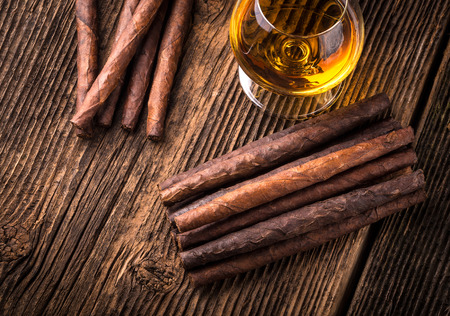 quality cigars and cognac on an old wooden tableの写真素材