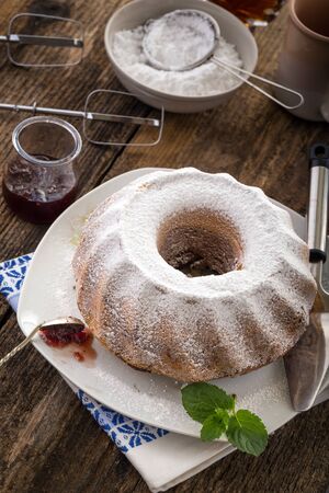 ring cake sprinkled with sugar on old wooden tableの写真素材