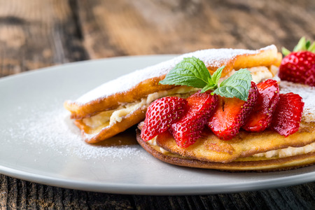 filled with homemade pancakes with strawberries and maple syrupの写真素材