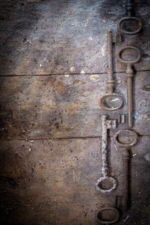 Old rusty keys on a wooden table without lockの写真素材