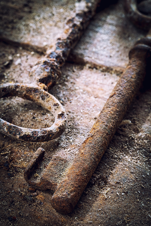 Old rusty keys on a wooden table without lockの写真素材