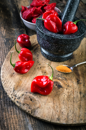 Habanero Red on wooden table very strongly hot pepperの写真素材