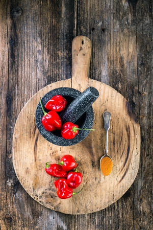 Habanero Red on wooden table very strongly hot pepperの写真素材