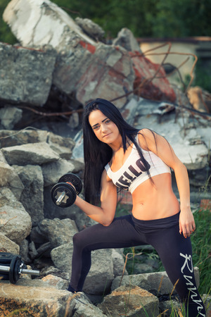 Pretty young fitness girl working out with dumbbell.の写真素材