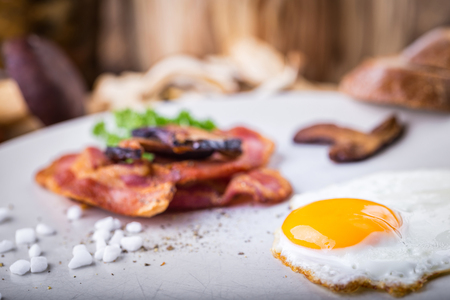Egg with mushrooms and bacon on the plate with salt and pepper.の写真素材