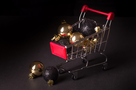 chrome shopping cart with gold and black christmas ballsの写真素材