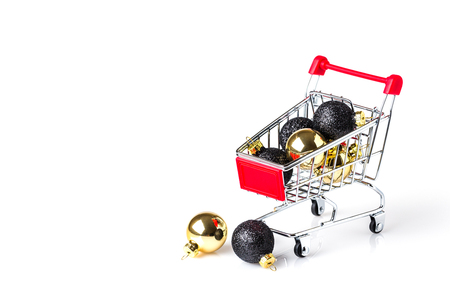 chrome shopping cart with gold and black christmas ballsの写真素材