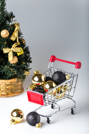 chrome shopping cart with gold and black christmas ballsの写真素材