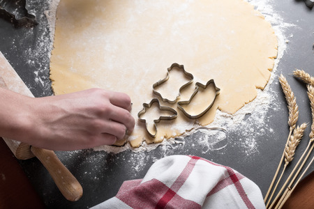 Cutting dough on different shapes, with steel cutters, on the black backgroundの写真素材