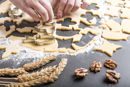 Cutting dough on different shapes, with steel cutters, on the black backgroundの写真素材