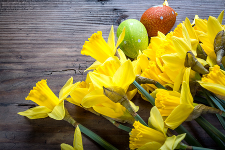 Bunch of daffodils on the wooden background with easter eggs for Easterの写真素材