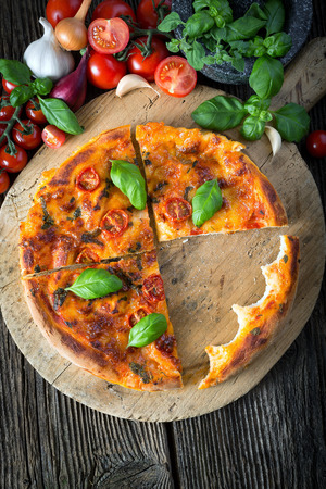 homemade pizza margherita with mozzarella, basil and tomatoes, bite offの写真素材
