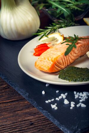 Grilled Salmon with lemon, herbs and pesto. Red carrots. Potato salad.の写真素材