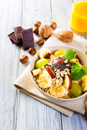 Oatmeal with yoghurt, apple, banana, grape and chia seeds. Bowl of fresh fruit.の写真素材