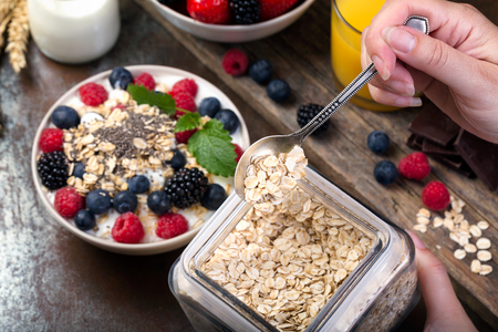 Spoon of oatmeal. Bowl with berries. Selective focus.の写真素材