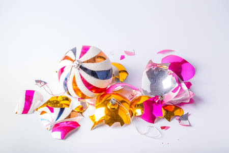 Broken old vintage Christmas ball on white backgroound. Crashed yellow and pink bauble.の写真素材
