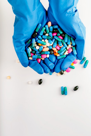 Hands full of medication with different types and colours. Medical tools. Tablets and pils.の写真素材