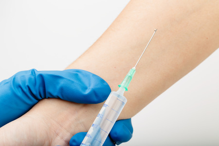 Blue latex glove injected cure for female.Caucasian skin.の写真素材