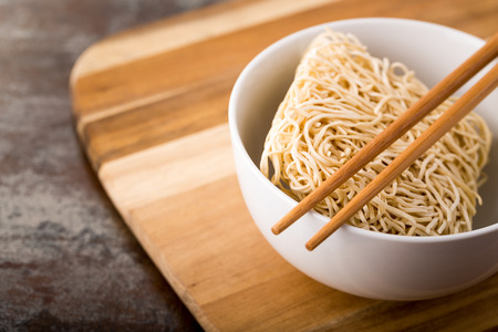 Chinese dried noodles in a bowl. Bamboo sticks. Asian cuisine.の写真素材