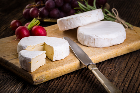 Cheese with white mold. Camembert or brie type. Radish and grapes. Healthy breakfast.の写真素材