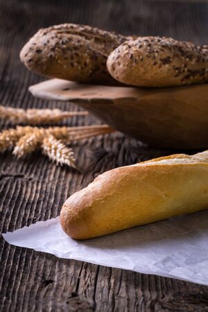 Fresh cereal pastry. Freshly baked white and brown baguette with wheat ears and grain.の写真素材