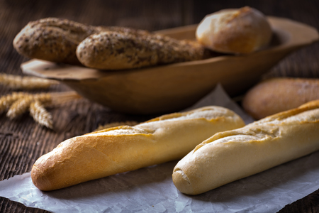 Fresh cereal pastry. Freshly baked white and brown baguette with wheat ears and grain.の写真素材