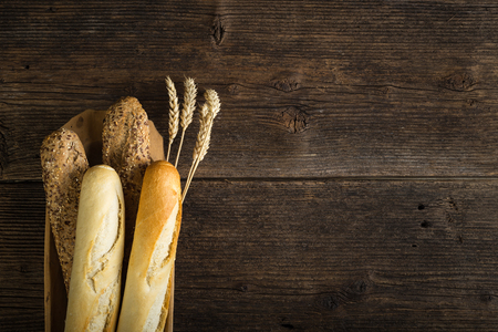 Fresh cereal pastry. Freshly baked white and brown baguette with wheat ears and grain.の写真素材